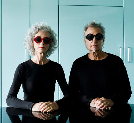 Ruth and John Fluevog pose as models for the red and black Fluevog x Fellow Earthlings Clarity sunglasses.