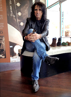 Alice Cooper sits in a Fluevog store wearing the Swordfish shoes.
