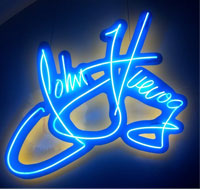 John Fluevog signature in a neon sign.